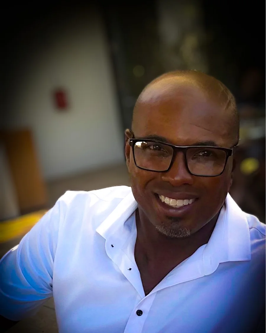 Dave Davis, editor of B.Y.L.T. BLACK, smiling in a white shirt.